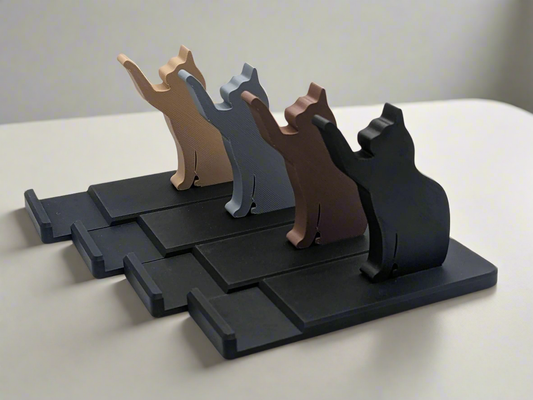 A collection of cat phone holders in different colours.